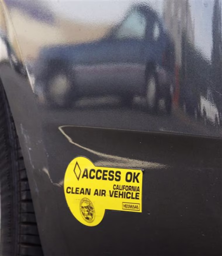 In a June 28, 2011 photo, other autos are reflected in the curved bumper of a Toyota Prius hybrid auto bearing California DMV decals in Los Angeles.  The program that allowed single occupants of hybrids to use carpool lanes expires at the end of June. (AP Photo/Reed Saxon)